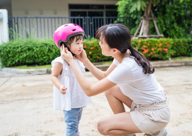 Mother putting helmet on child image